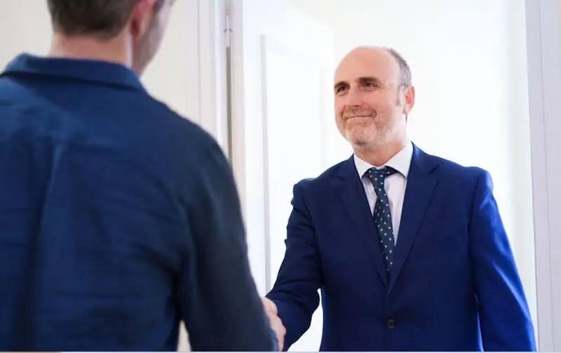 Miguel Javaloyes da la bienvenida a un cliente con un apretón de manos en la entrada del despacho.