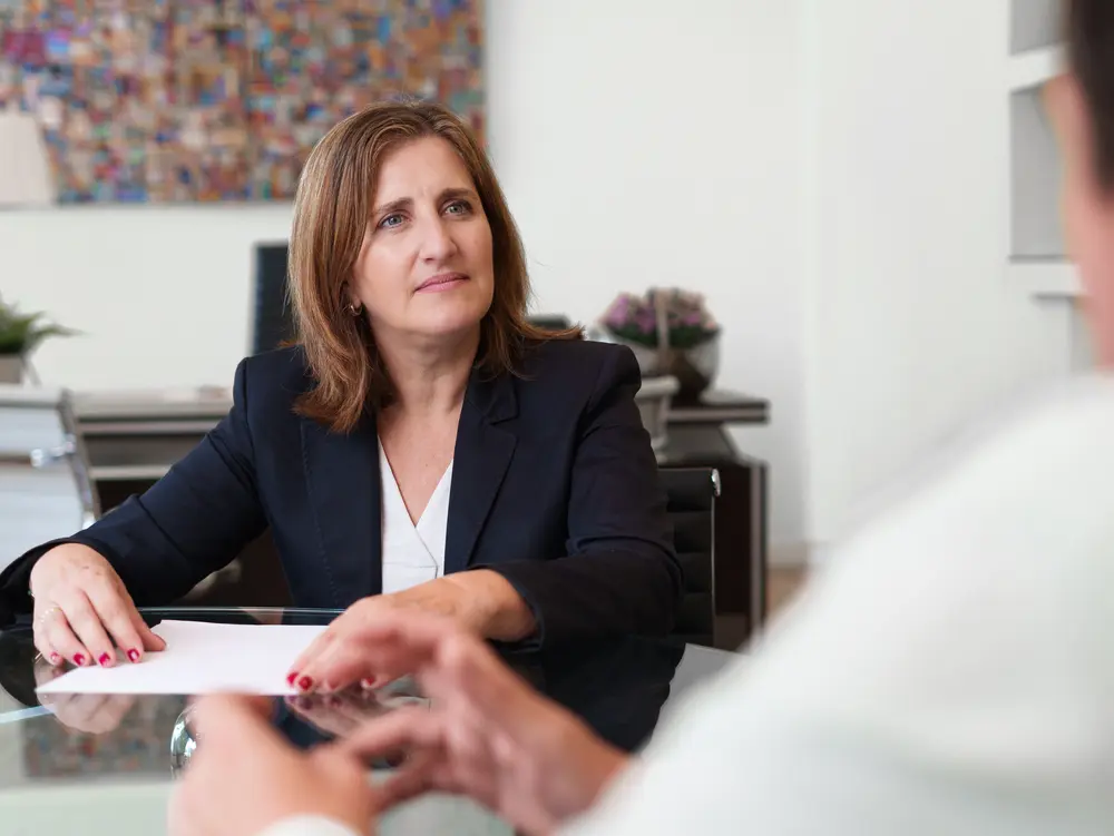 Abogada de Javaloyes Legal escucha con máxima atención a un cliente durante una reunión en su despacho.