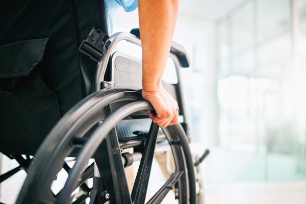 Persona en silla de ruedas empujándose, ilustrando el contexto de la incapacidad permanente y su compensación económica.