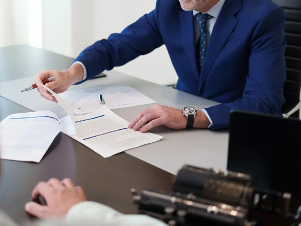 Abogado de Javaloyes Legal revisa documentos junto a un cliente durante una reunión profesional.