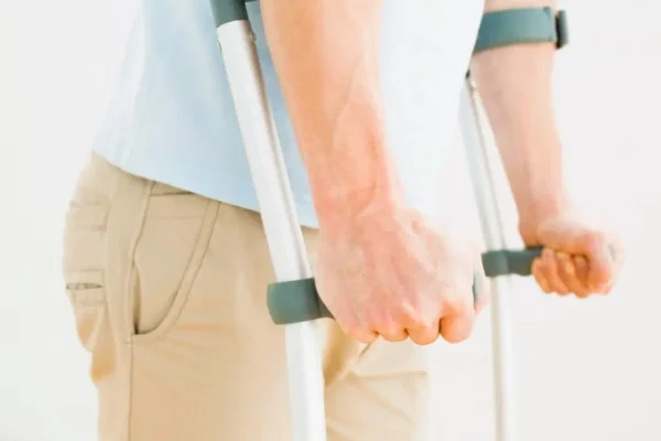 Persona usando muletas, ilustrando el momento en que el INSS propone una incapacidad permanente tras valoración médica.