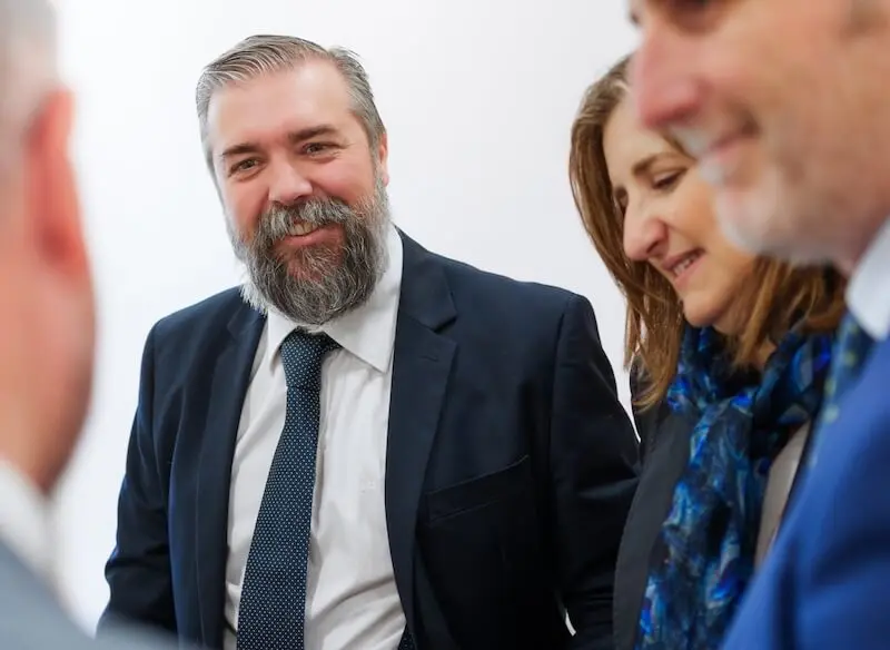 Miembros del equipo de Javaloyes Legal conversan sonrientes durante una reunión interna en el despacho.