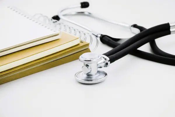 Estetoscopio junto a cuadernos, simbolizando las probabilidades de ganar un juicio por negligencia médica.