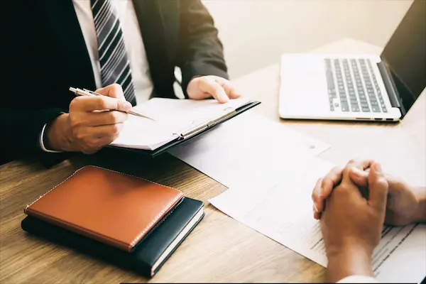 Dos personas revisan documentos legales en una oficina, en contexto de un recurso de reposición.