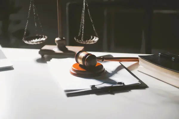 Mazo judicial, balanza y documentos legales en mesa, ilustrando el concepto de responsabilidad civil.