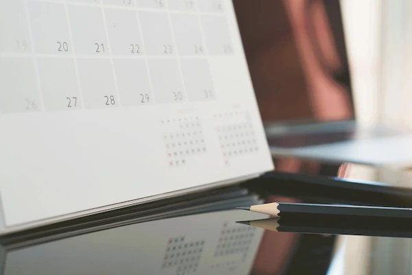 Calendario de sobremesa junto a lápices, simbolizando los plazos legales del recurso contencioso-administrativo.