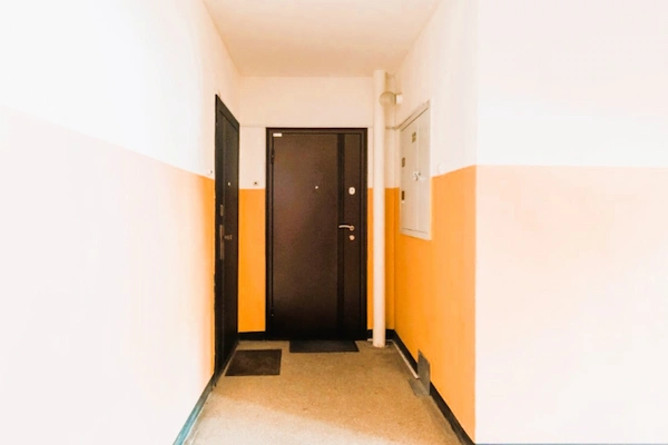 Puerta de vivienda en edificio comunitario, relacionada con la posible venta del antiguo piso del portero.