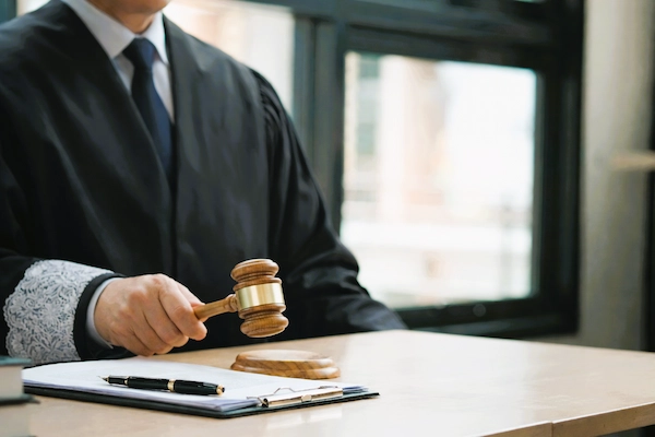 Juez con mazo junto a fajos de billetes y documentos, en contexto del delito de insolvencia punible.