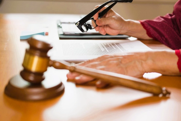 Mano revisando documentos legales con mazo judicial, ilustrando el concepto del recurso de revisión penal.