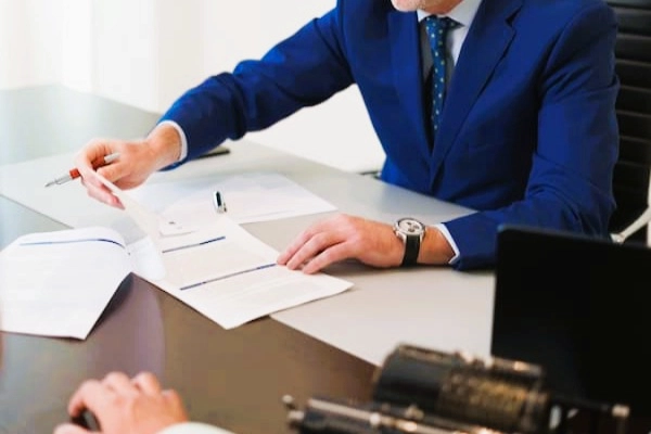 Abogado revisa documentos con cliente, explicando el concepto de autocartera en una sociedad limitada.