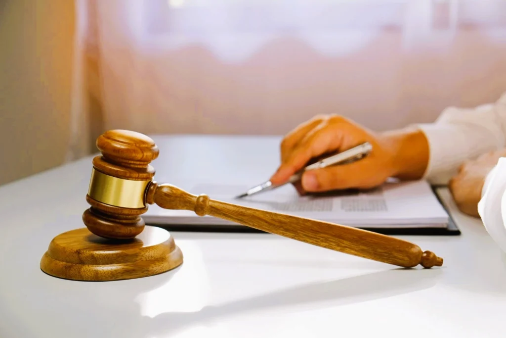 Mazo judicial sobre mesa y mano firmando documento, aludiendo a la reforma en casación por unificación de doctrina.