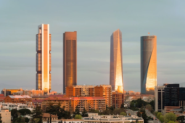 Vista de las Cuatro Torres en Madrid al atardecer, símbolo del entorno empresarial de la capital.