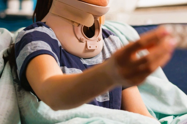 Mujer con collarín tras accidente ilustra el tiempo de espera para cobrar una indemnización por accidente de tráfico.