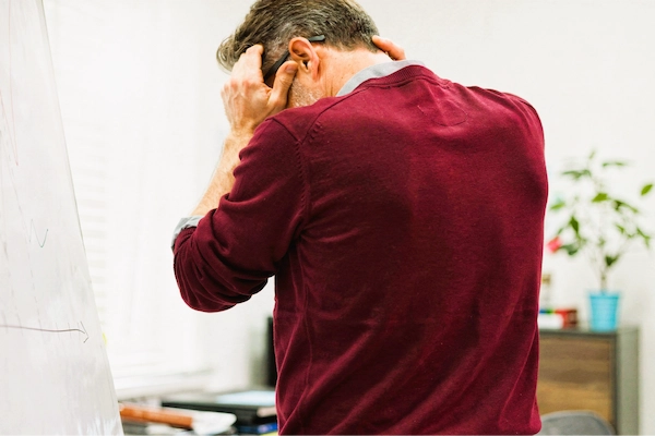 Hombre angustiado se lleva las manos a la cabeza, representando una posible negligencia médica en un ictus.