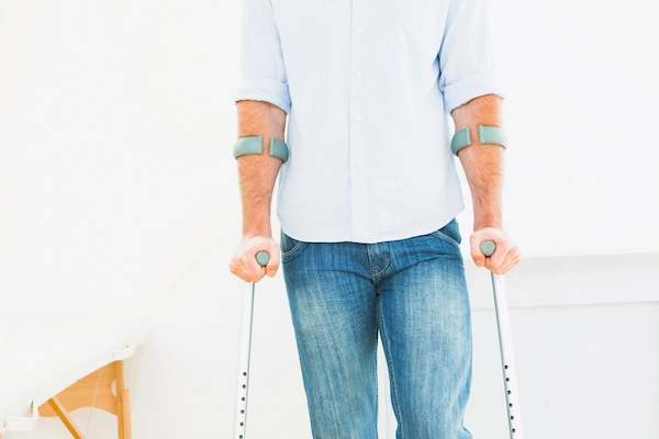 Hombre con muletas representa una situación de incapacidad, vinculada a la duda legal sobre pasar de total a absoluta.