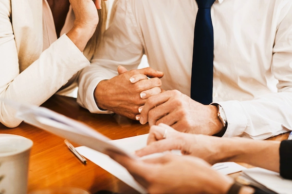 Pareja toma de la mano mientras consulta documentos legales, ilustrando el concepto de usufructo en una herencia.