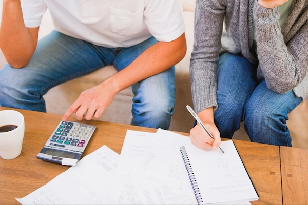 Pareja revisando cuentas y documentos, ilustrando la liquidación de gananciales, reparto de bienes comunes tras separación o divorcio.
