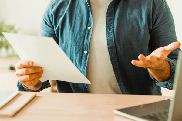 Persona revisando un documento de reclamación de deudas, proceso legal para exigir el pago de una cantidad pendiente paso a paso.