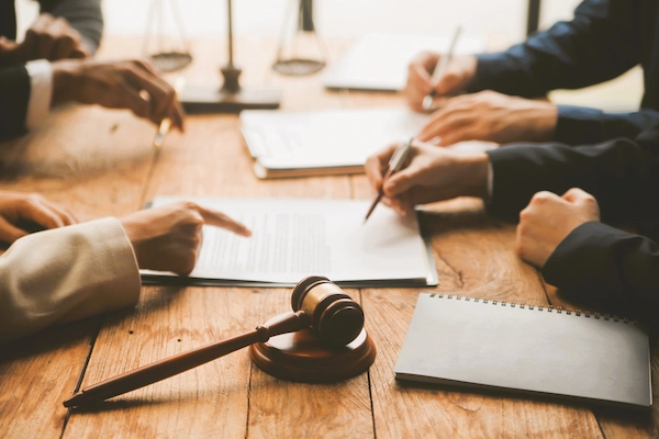 Profesionales firmando documentos legales con mazo judicial, representando cómo parar una ejecución judicial legalmente