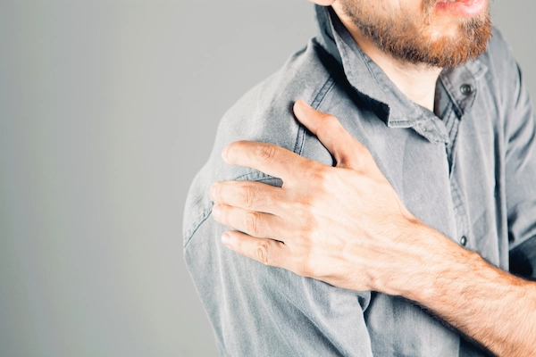 Hombre con dolor en el hombro por síndrome subacromial; incapacidad laboral: baja cuando una lesión impide trabajar.