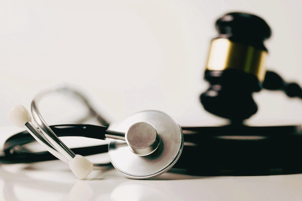 Estetoscopio y mazo judicial simbolizan hemorragias subaracnoideas y negligencias médicas, daños por errores sanitarios graves.