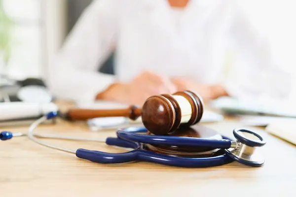 Mazo judicial y estetoscopio simbolizan la responsabilidad civil médica, obligación legal por daños causados por mala praxis sanitaria.
