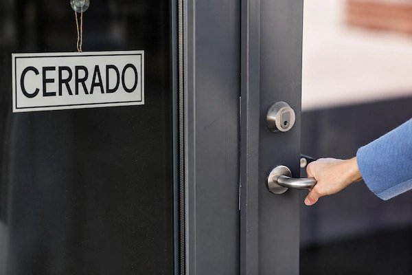 Cartel de cerrado en la puerta de un negocio que representa el despido por cierre de empresa y el fin de la actividad.