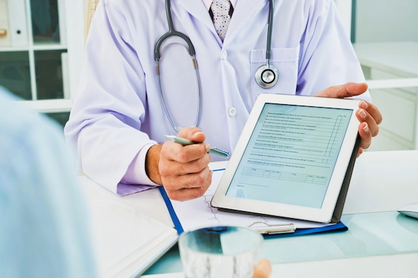 Médico muestra un formulario digital sobre despido por no apto, situación laboral derivada de una evaluación médica.