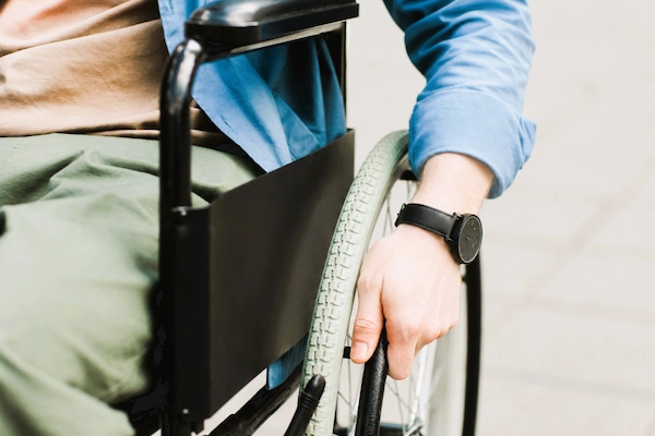Persona en silla de ruedas, situación asociada a la gran incapacidad, grado que requiere ayuda de terceros para actos básicos.