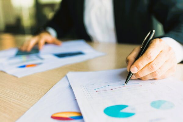 Persona analizando gráficos financieros. El levantamiento del velo societario permite exigir responsabilidad detrás de una empresa.